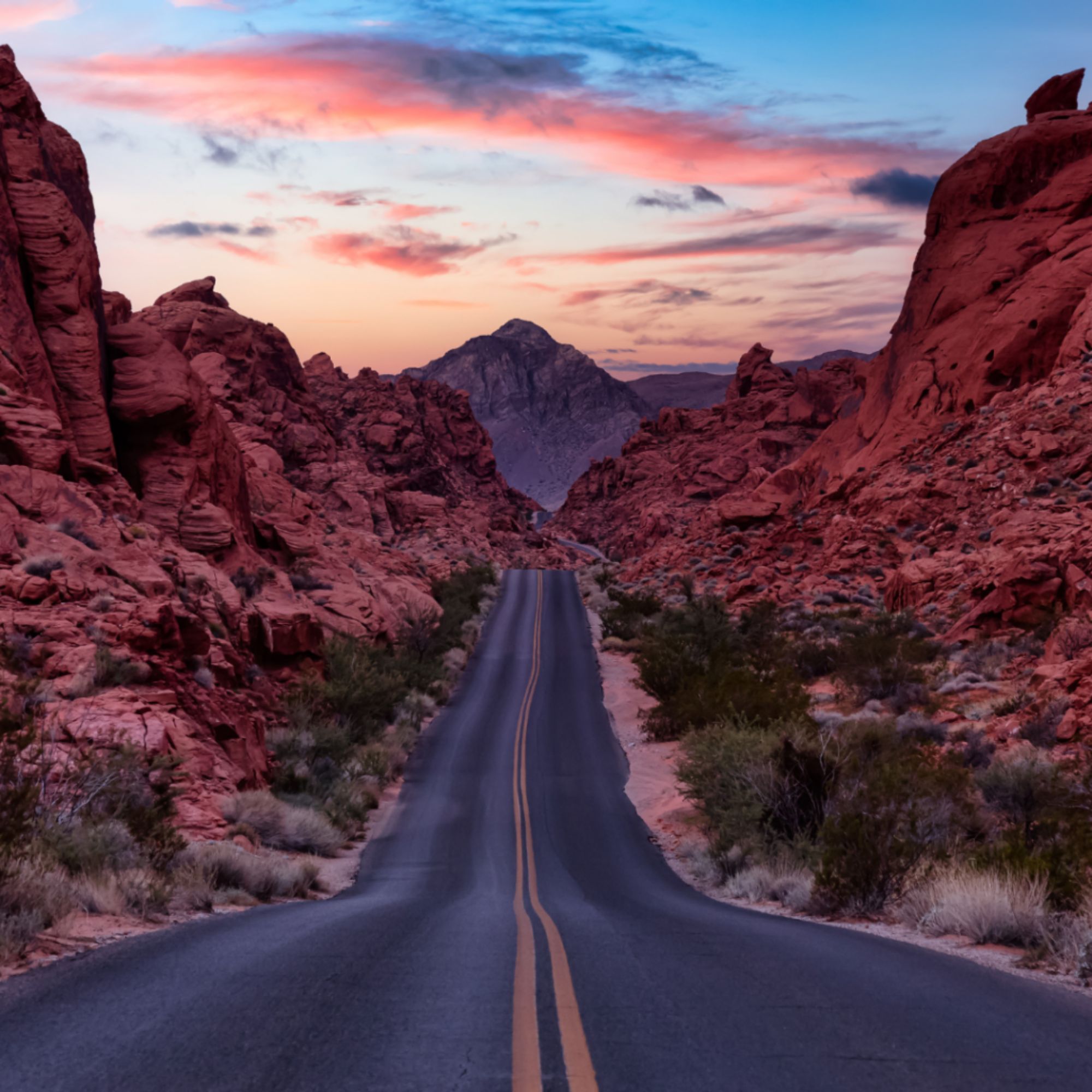 A scenic road cutting through rugged red rock canyons at sunset, symbolizing the journey rural healthcare organizations take to achieve financial stability, sustainable growth, and stronger patient care outcomes.