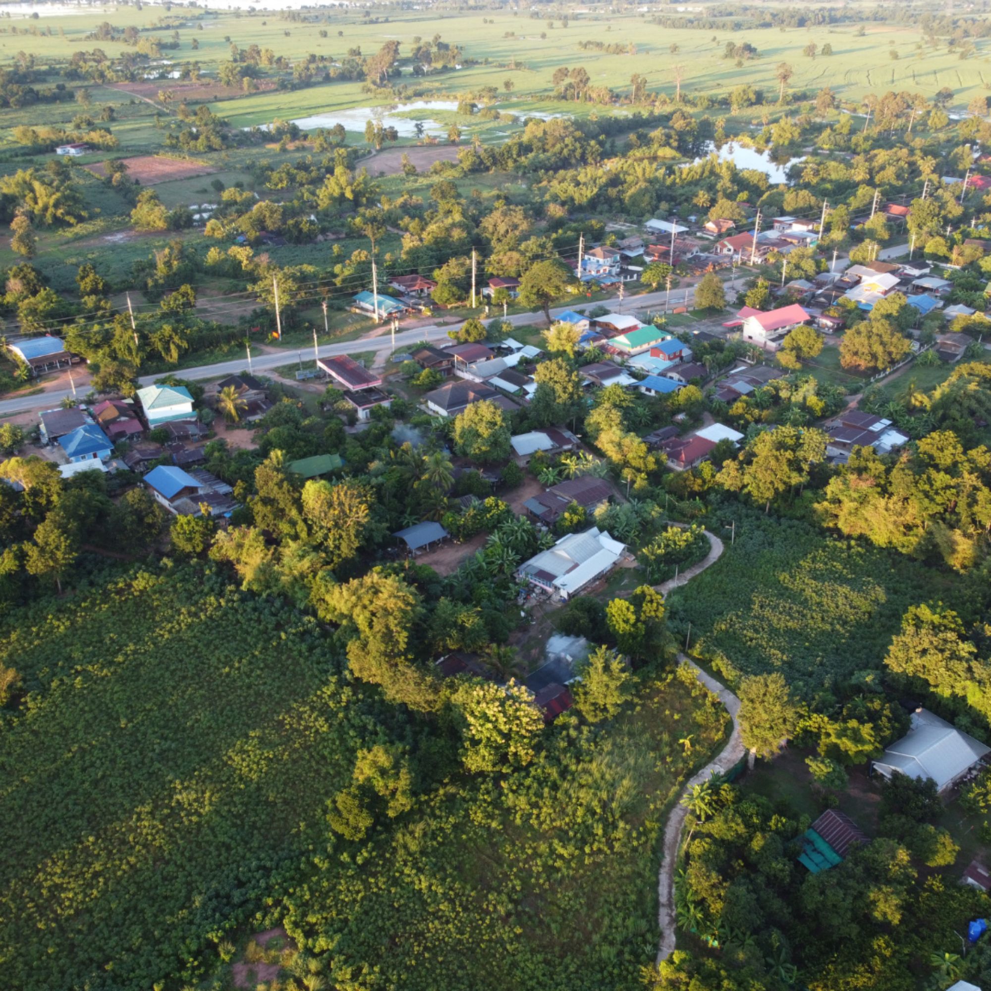 Rural community surrounded by farmland and green countryside viewed from above.