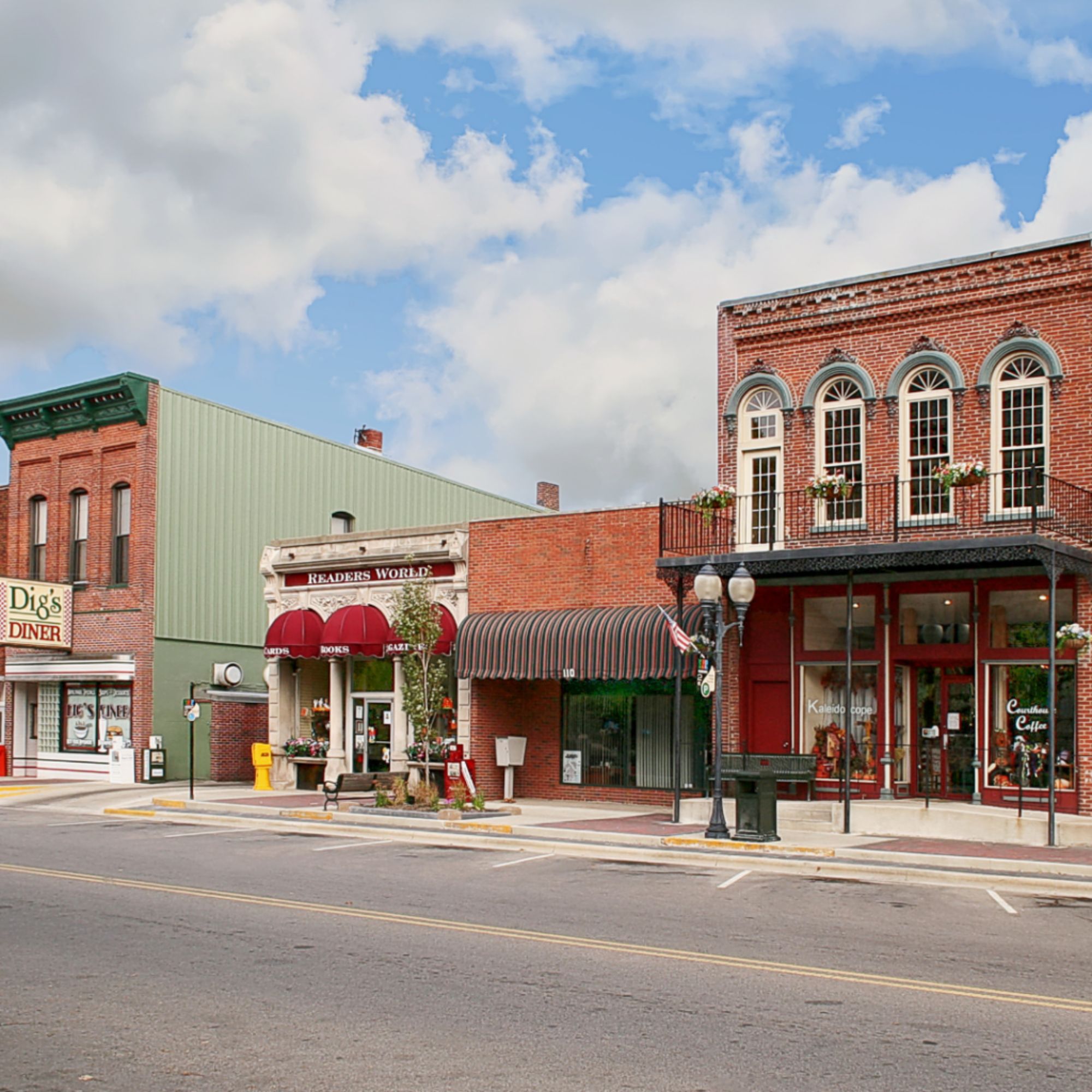 Historic brick storefronts line a small-town Main Street, featuring local businesses, wide sidewalks, and a welcoming downtown atmosphere that reflects the vitality of rural communities.