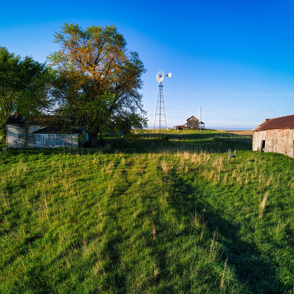 A green rural Nebraska farm with barn and windmill.