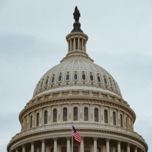 A captivating shot of the iconic US Capitol building dome in Washington, D.C. with the American flag.