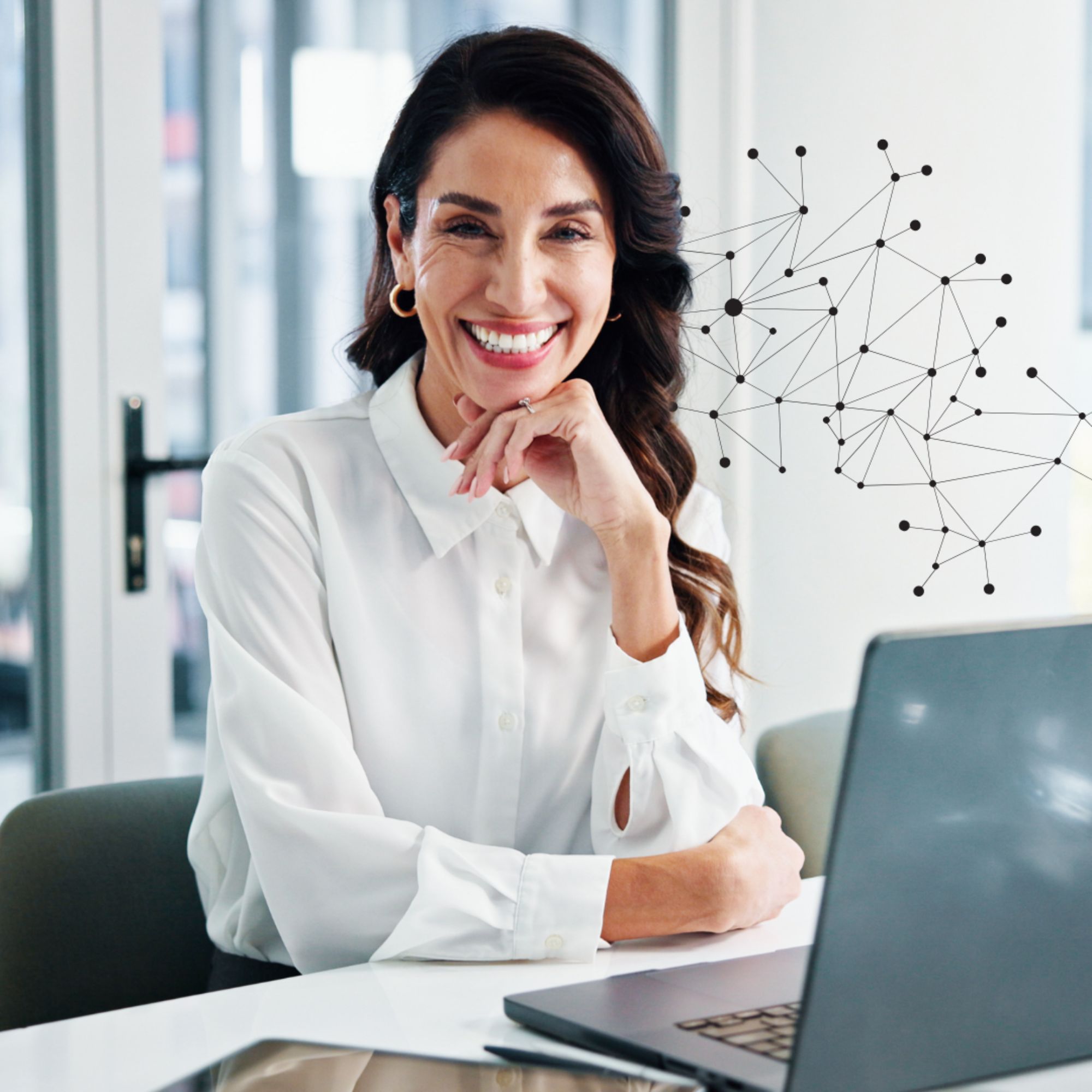 Female healthcare admin professional sitting at a desk smiling in front of her work laptop