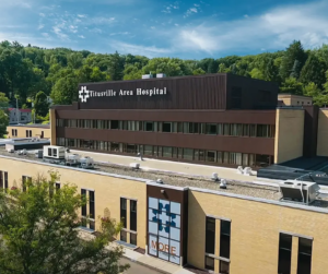 Aerial view of Titusville Area Hospital, a critical access hospital in northwest Pennsylvania, surrounded by wooded hills.