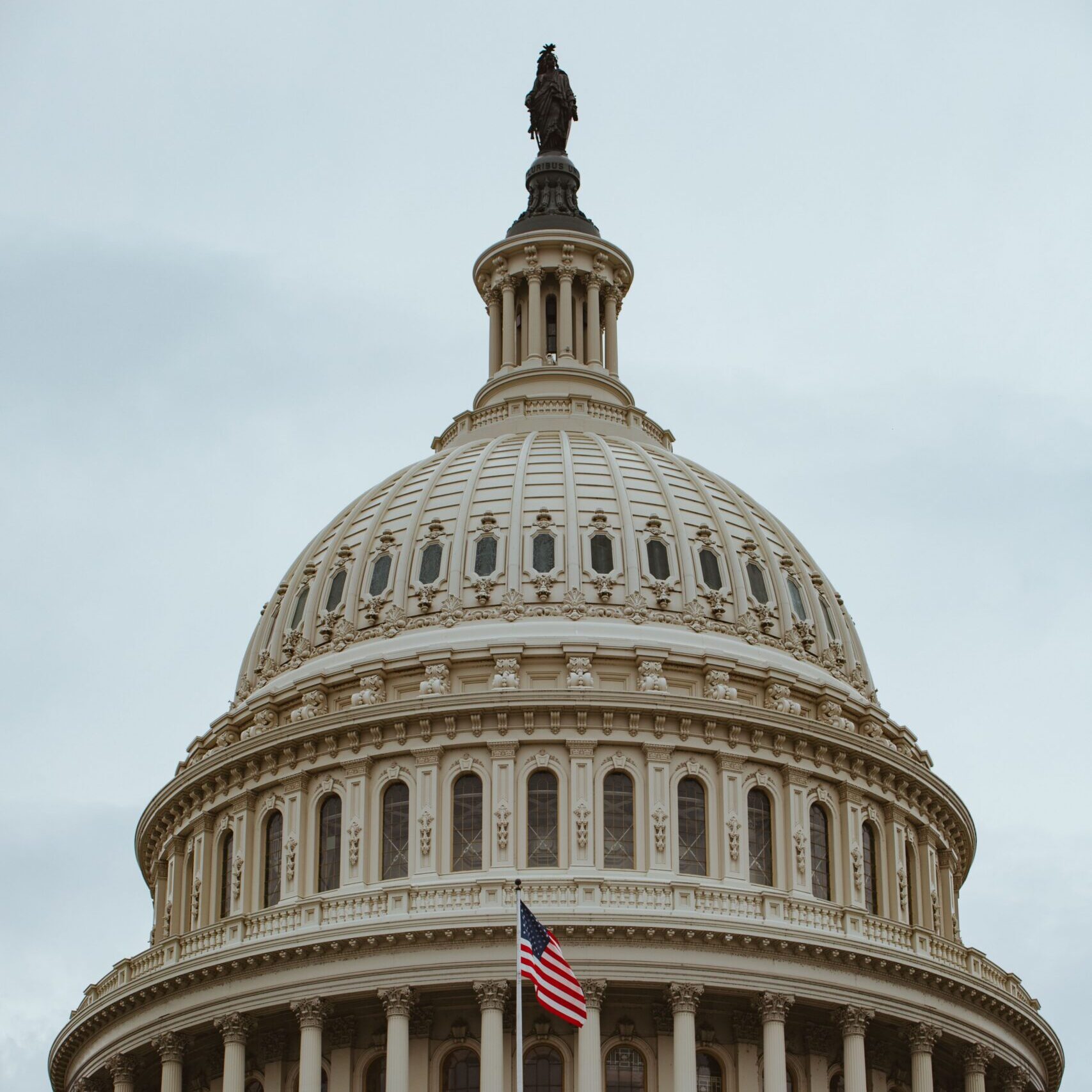 A captivating shot of the iconic US Capitol building dome in Washington, D.C. with the American flag.