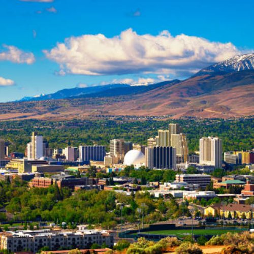 Downtown Reno skyline, Nevada, with hotels, casinos and the surrounding High Eastern Sierra foothills