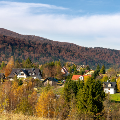 Rural community surrounded by autumn trees and rolling mountains, representing communities impacted by the Rural Health Transformation Program.