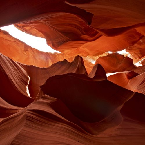 Light shining through a winding sandstone canyon, symbolizing how clarity, insight, and guidance can reveal new paths forward through complex challenges and help organizations make confident decisions.