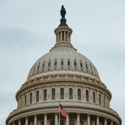 A captivating shot of the iconic US Capitol building dome in Washington, D.C. with the American flag.